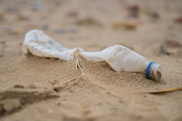  semi-buried plastic bottle on a beach of the Mediterranean Sea