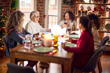 Beautiful group of women smiling happy and confident. Eating roasted turkey celebrating christmas at home