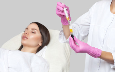Cosmetologist does prp therapy on the face of a beautiful woman in a beauty salon. There is in...
