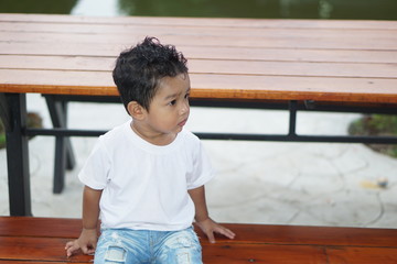 Portrait of cute happy Asian kid looking some one around.