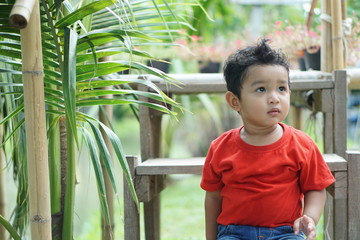 Portrait of cute happy Asian kid looking some one around.