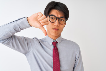 Chinese businessman wearing tie and glasses standing over isolated white background with angry...