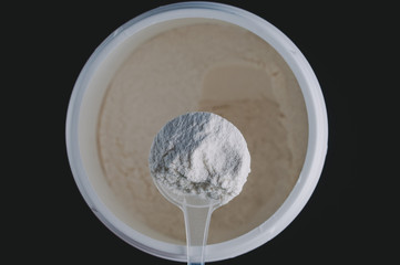 Sports Nutrition Powder. Soluble bcaa in a measuring spoon in the hand to increase the endurance and strength of the athlete. On a black background, isolate.