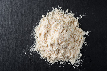 White sports nutrition powder. Soluble protein to increase athlete's stamina and strength. On a stone gray background.