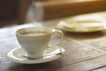 In the morning, a cup of espresso on a wooden table in a coffee shop or coffee