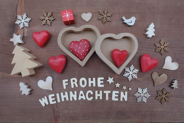 Frohe Weihnachten, german Merry Christmas composed with wooden letters and ornaments over wooden board