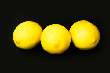 three lemons on a black background