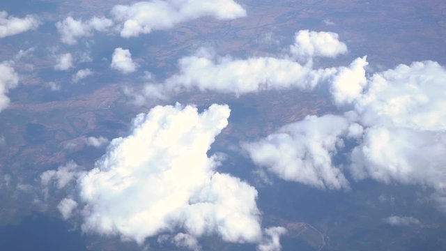 Amazing white fluffy clouds as seen from window of flying plane. Real time full hd video footage.