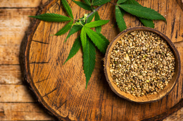 Cannabis seeds and marijuana leaves in a bowl on