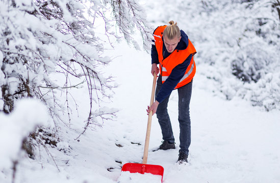 Man cleaning snow with shovel 