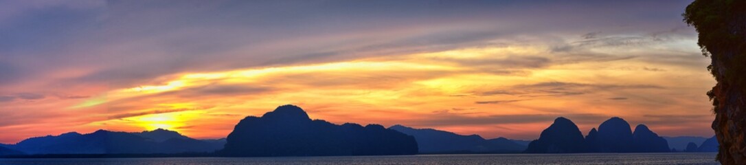 Fototapeta na wymiar Islands Sunset, Ocean panorama views near Phuket with deep Red, Orange, Purple and Blue, mountains, twilight in Thailand. Including Phi Phi, Ko Rang Yai, Ko Li Pe and other islands. Asia.
