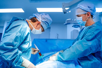 Stem cells operation. Health care concept. Surgeons team working. Bone marrow transplant operation. Plasma in syringe. Selective focus. Medical room background. - obrazy, fototapety, plakaty