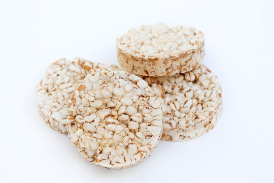 Round crunchy crispbreads on a white background. Round shaped cereal bread, healthy food without yeast. puffed multigrain crispbreads for diet.
