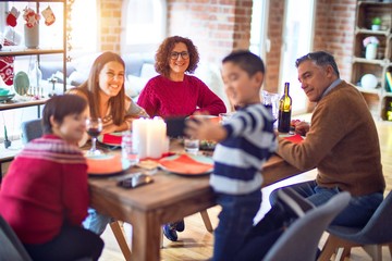 Beautiful family smiling happy and confident. Eating roasted turkey make selfie by smartphone celebrating christmas at home