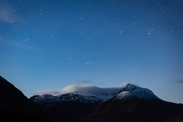 Fototapeta na wymiar the night sky above buachaille etive mor and surrounding mountains of glencoe in the argyll region of the highlands of scotland during a clear dark sky night in autumn
