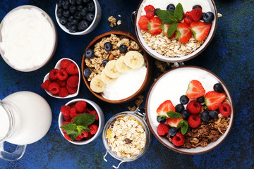 Tasty homemade granola served on table. Healthy breakfast with a bowl of oatmeal with banana, blueberries, strawberries and healthy food for Breakfast