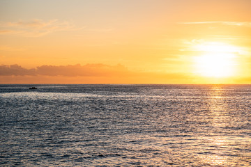 Sunrise ober the sea. Boat on the horizon.