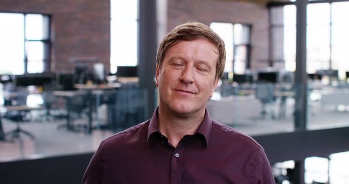4K Businessman in large modern office building nodding during boring conference call