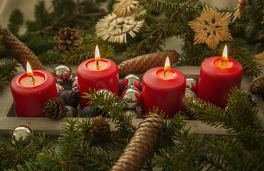 Adventkranzdeko 4 rote kerzen brennen.