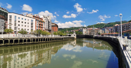 Naklejka premium Both banks of the Ria de Bilbao with boat or boat going up the riverbed 