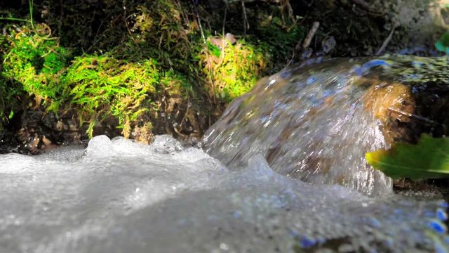 peque&ntilde;a cascada de arroyo monta&ntilde;a en mucha espuma en c&aacute;mara lenta