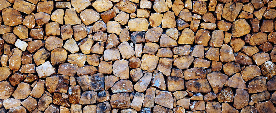 Stones, rocks and boulders - as a stone wall background texture / abstract design.