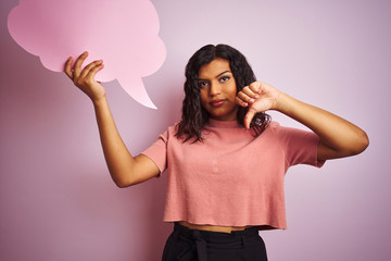 Transsexual transgender woman holding speech cloud bubble over isolated pink background with angry face, negative sign showing dislike with thumbs down, rejection concept