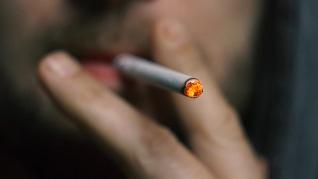 young man smoking a cigarette close-up. smoke fire light. boy smokes. man's lips. addiction tobacco smoker poison.