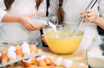 funny girls kids are preparing the dough in the kitchen.