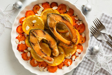 Fried carp fish slices with carrot and oranges. Traditional Polish Christmas eve dish.