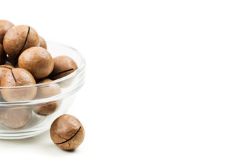 Raw not peeled whole macadamia nuts in glass bowl