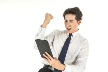 Portrait of smart young asian businessman wearing white shirt holding computer tablet feelings glad and raised fist on isolated white background and copy space.