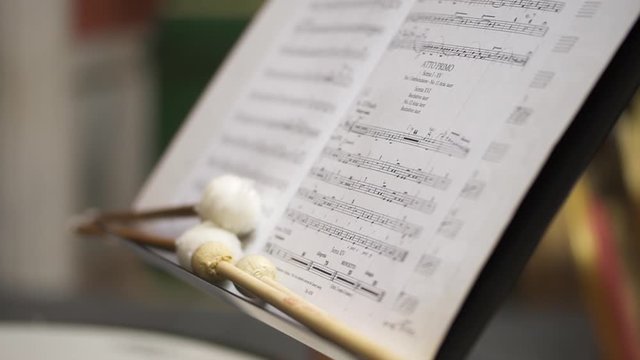 closeup shot of kettledrum musical instument, drum stick and sheet music. nobody, classic music, classical, percussion, no people concept. prepared for orchestra concert.