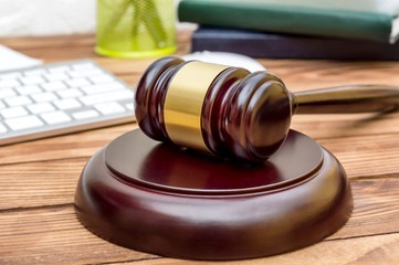 Obraz premium Judge's gavel on the office desk near wall.