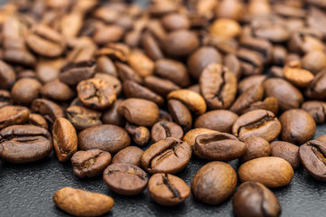 Heap of coffee beans on black. Close up.