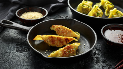 Steamed and Fried yaki Gyoza served on cast iron skillet, pan with sweet chilli sauce and sesame seeds