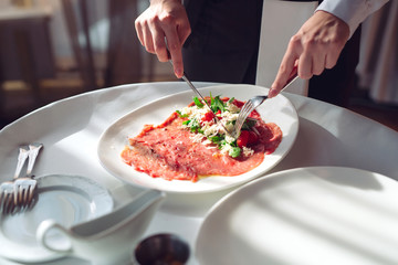 Red beef carpaccio in a white plate,