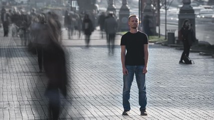 The man stands in the middle of urban crowdy stream. time lapse