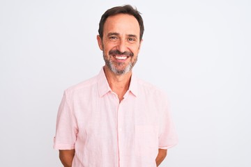 Middle age handsome man wearing casual pink shirt standing over isolated white background with a happy and cool smile on face. Lucky person.