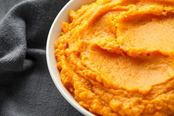 Mashed Sweet Potatoes in white bowl on wooden rustic table. Healthy food