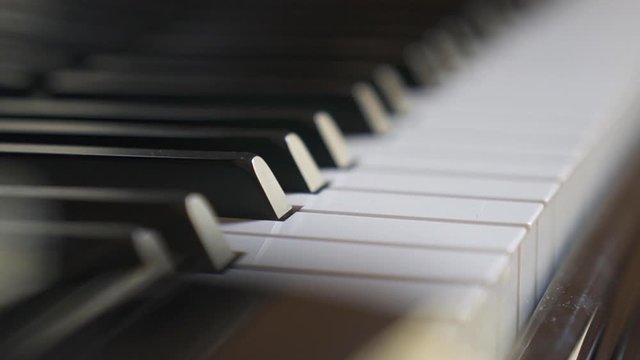 closeup of piano black and white keys wooden keyboard in motion. abstract isolated shot of musical instrument. aesthetic of music, sound, harmony, art, image concept.