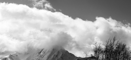 Panoramic view on winter snowy mountains in clouds