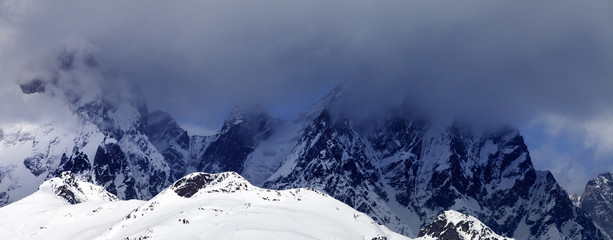 Fototapeta na wymiar Snowy rocks in haze and storm clouds before blizzard