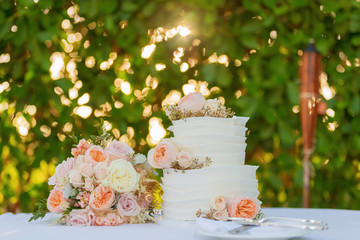 wedding cake and bridal bouquet on table