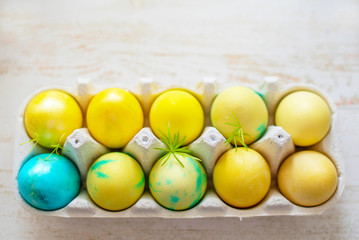 Colored blue and yellow Easter eggs in egg box. Traditional Christian eastertime. 