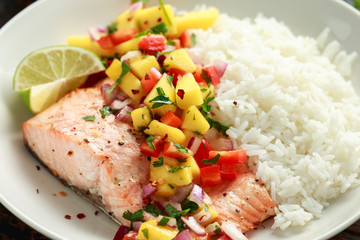Salmon with mango salsa and white rice on plate - obrazy, fototapety, plakaty