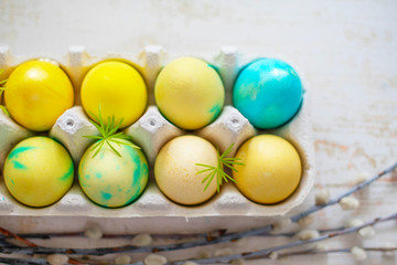 Colored blue and yellow Easter eggs in egg box. Traditional Christian eastertime. 