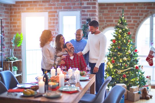 Beautiful family smiling happy and confident. Standing and posing with tree celebrating Christmas at home