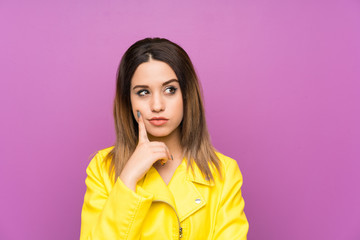 Fototapeta premium Young woman over purple background thinking an idea