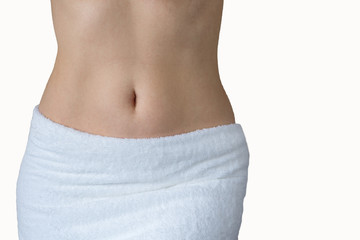 Slender female body wrapped in a white towel. Female health concept